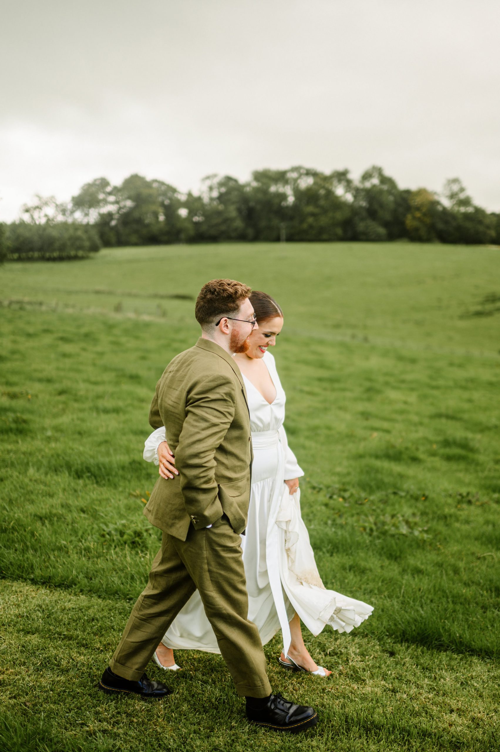 bride walkin barefoot on her way back from photographs taken by the lake in juniper barn