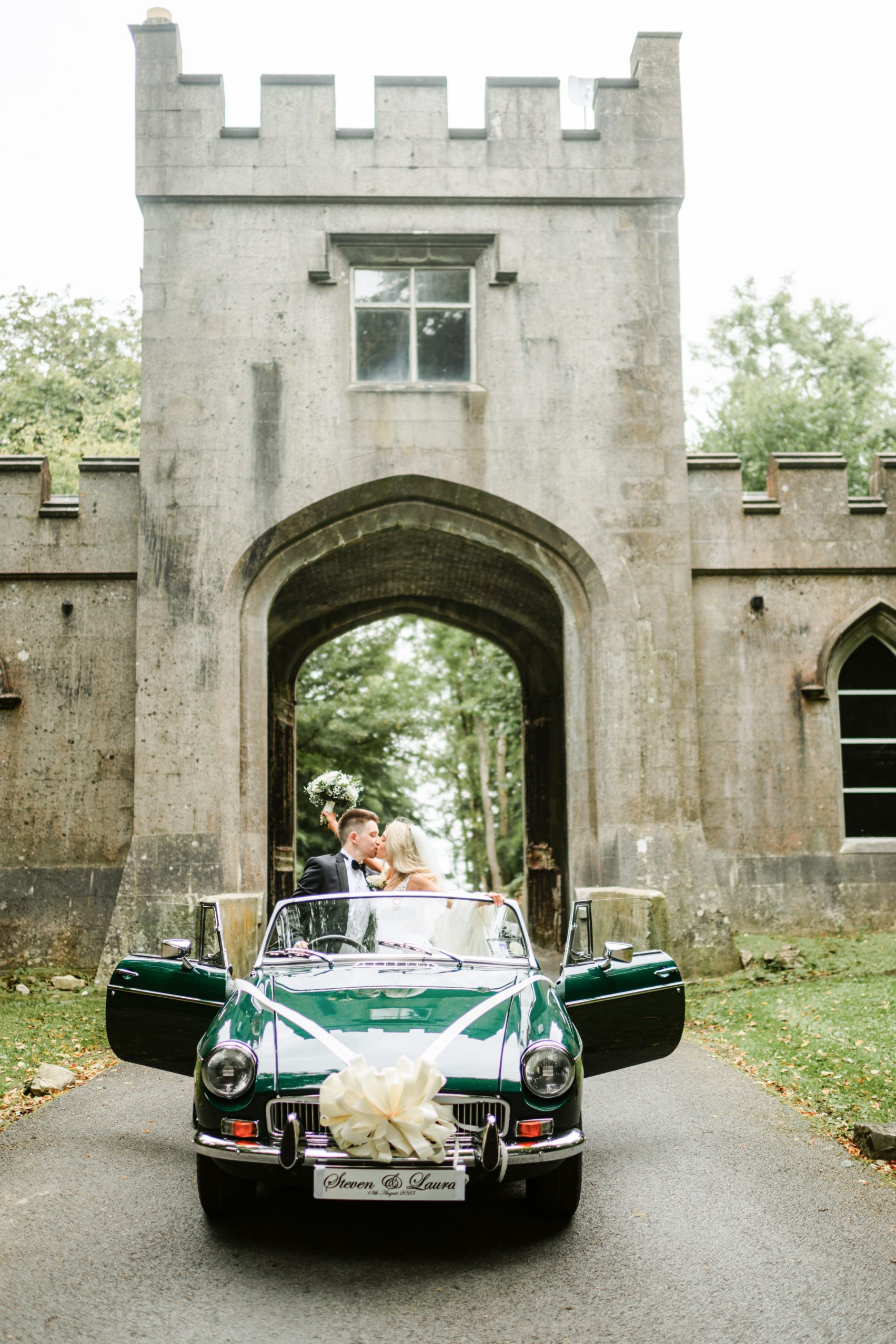 couple arriving for their destination wedding thorough irish castle gate house