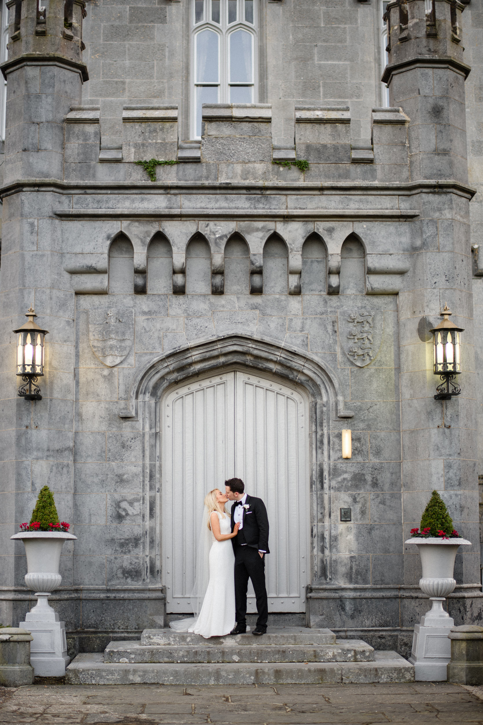 maried couples from USA at masive front door of droomoland castle in Ireland