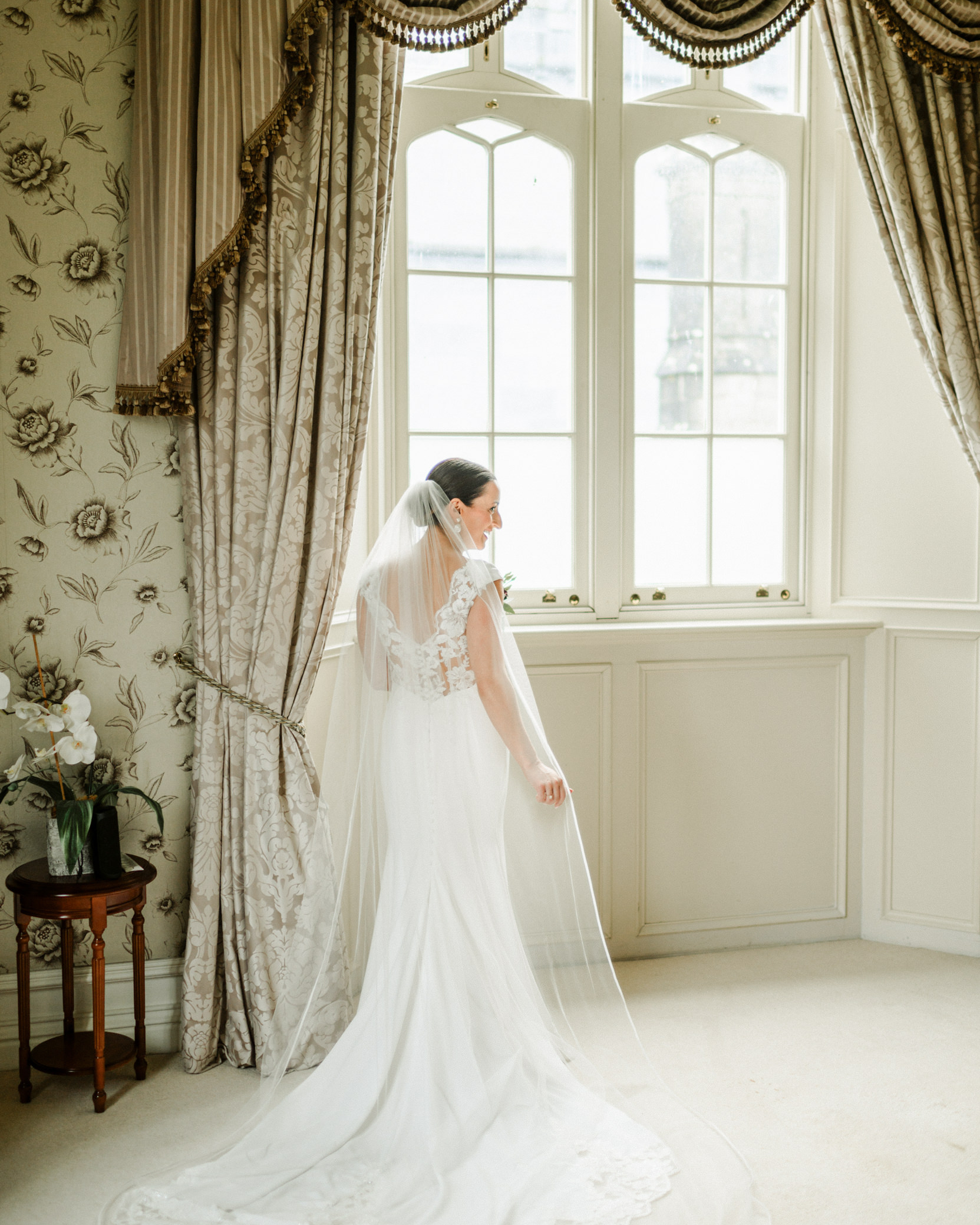 bride in white dress at front of window in bridal suite kilronan castle